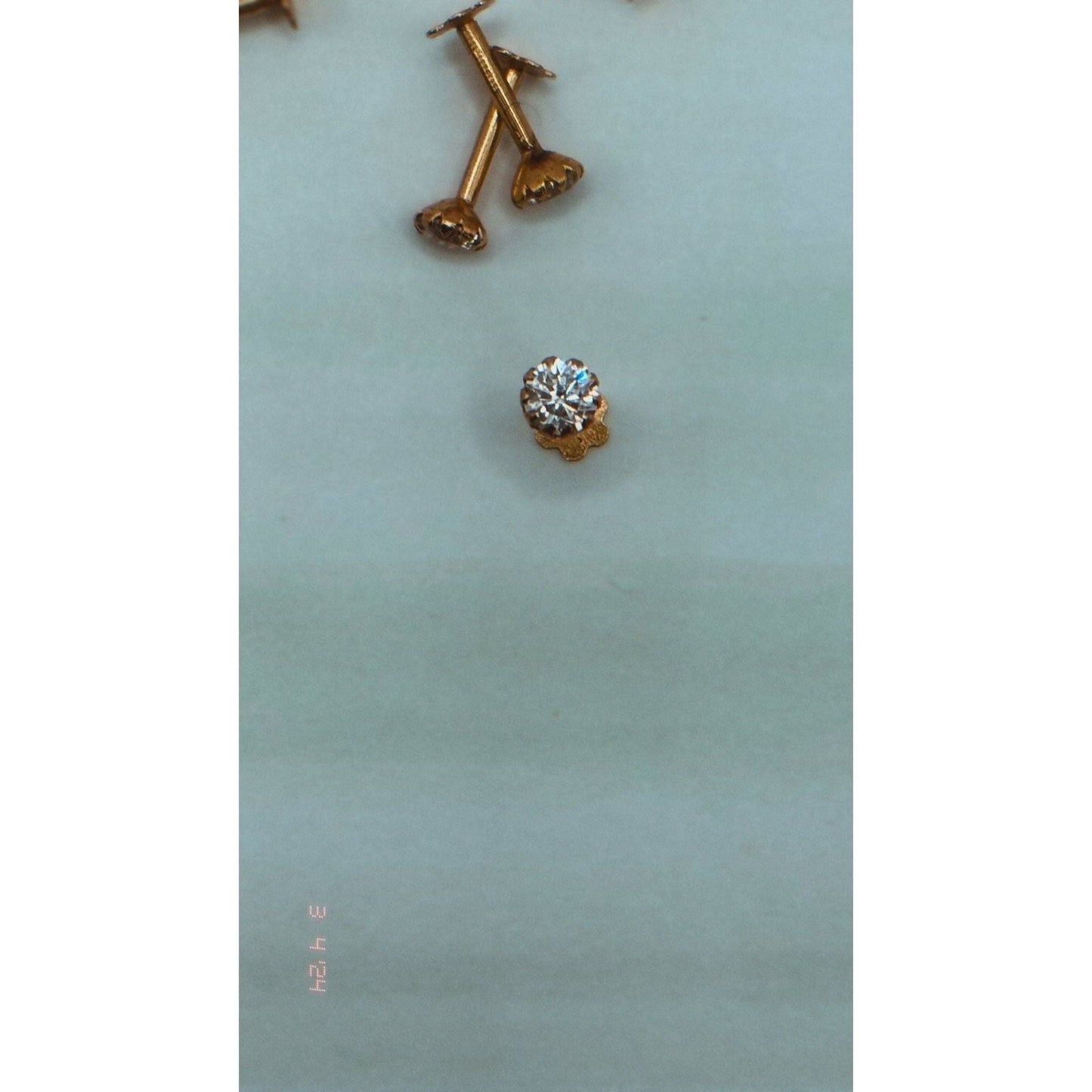 A 21 karat nose pin or nose stud is available with a traditional back. Please note that this product is only available for purchase in the United States at najmadesignsandc.co.