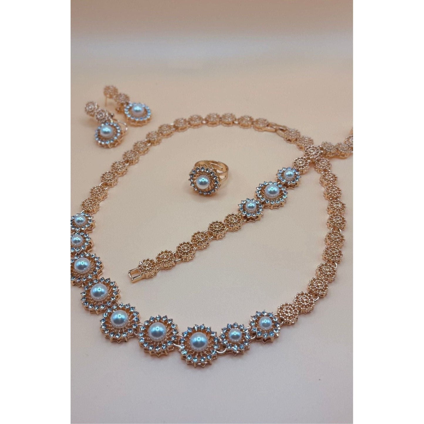 This beautiful pearl set features a one-carat gold setting. It includes an earring bracelet, a ring, and a necklace.