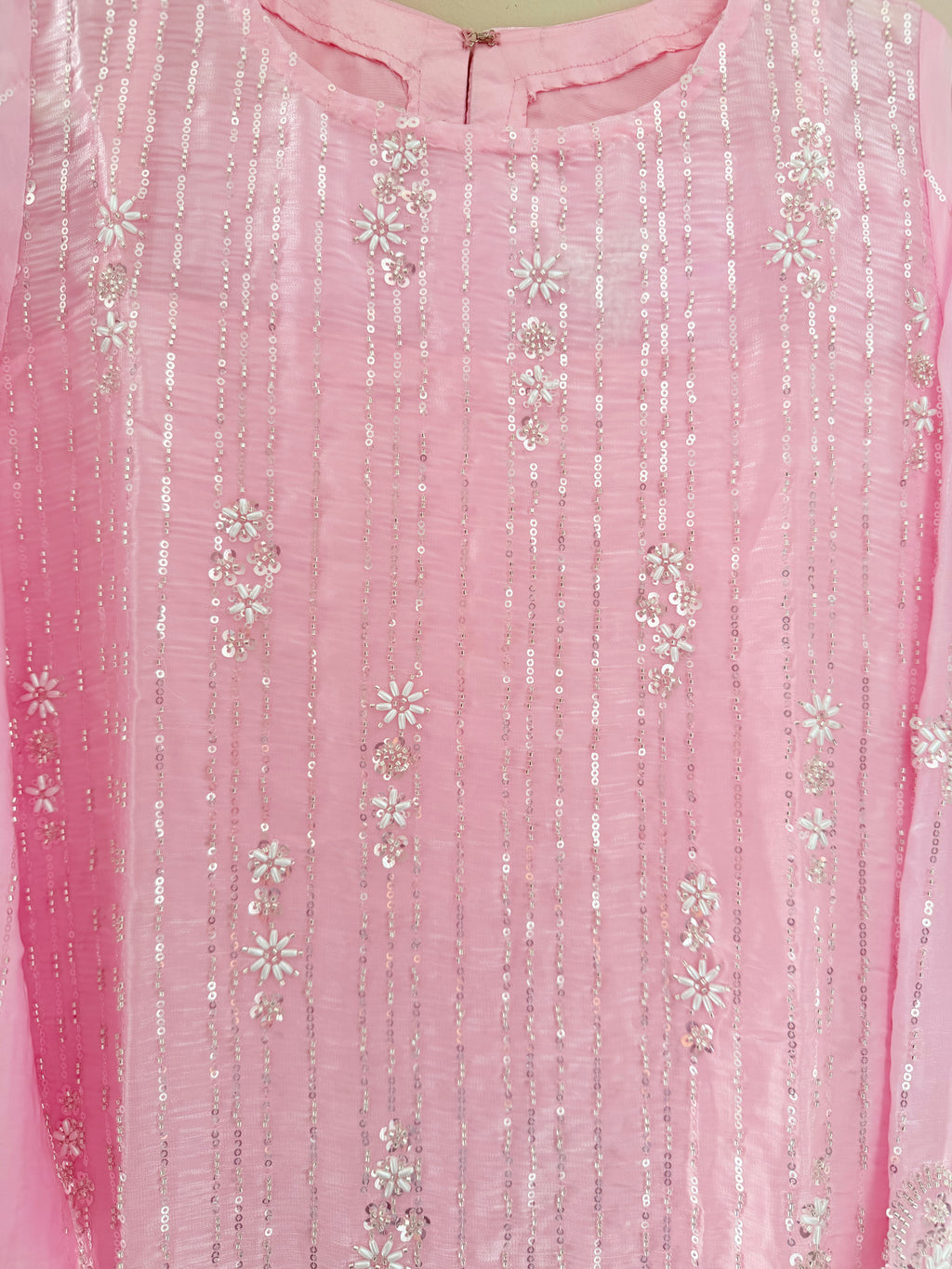 Close-up of a pink fabric with silver floral embroidery