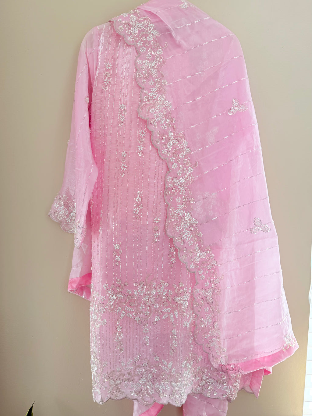 Pink embroidered fabric on a beige background