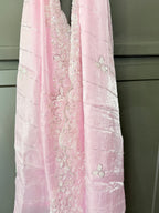 Pink embroidered fabric against a neutral background