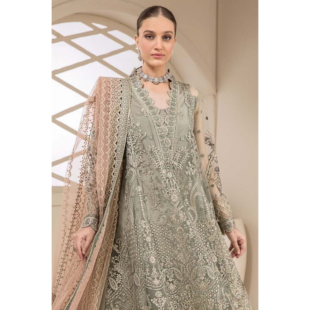 A frock in a vibrant green color, adorned with intricate embroidery, complemented by a dupatta in a peach-colored embroidery. 