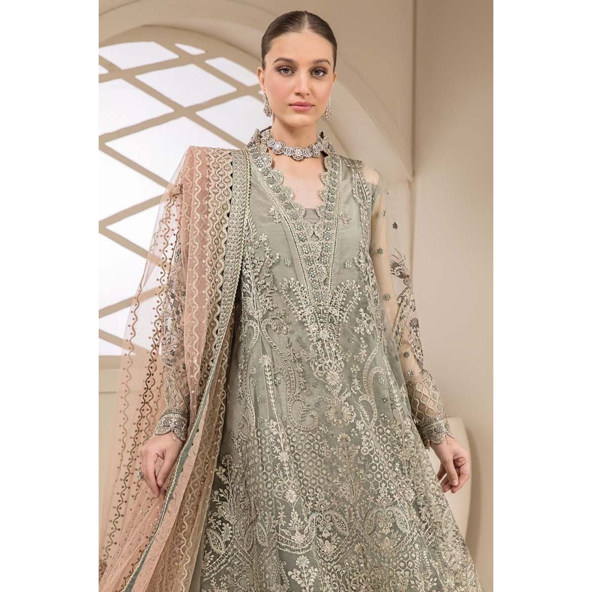 A frock in a vibrant green color, adorned with intricate embroidery, complemented by a dupatta in a peach-colored embroidery. 