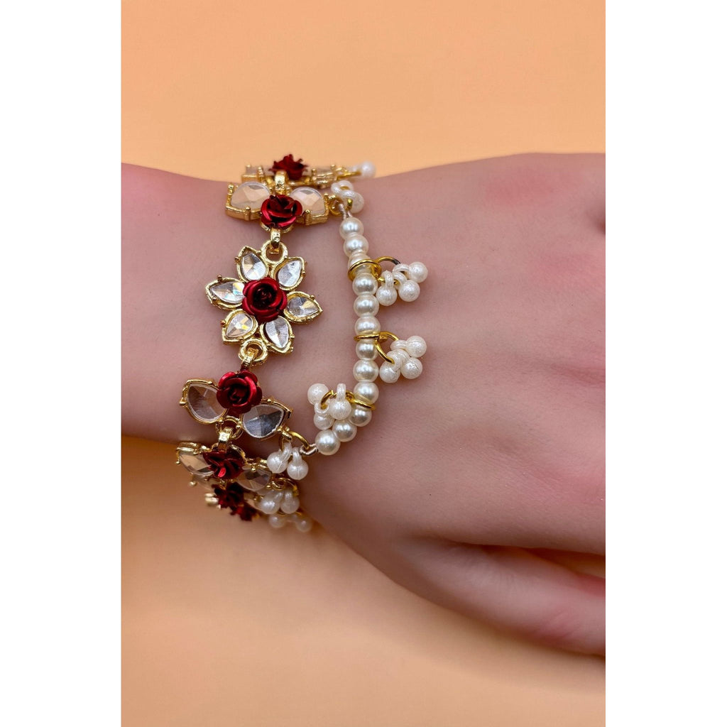 This Gulab kundan bracelet is a vintage piece of jewelry that adds elegance and beauty to any outfit. The braided design features a beautiful rose in either green or red, adding a touch of color and sophistication. Choose from two stunning options to complete your look with this stunning bracelet.