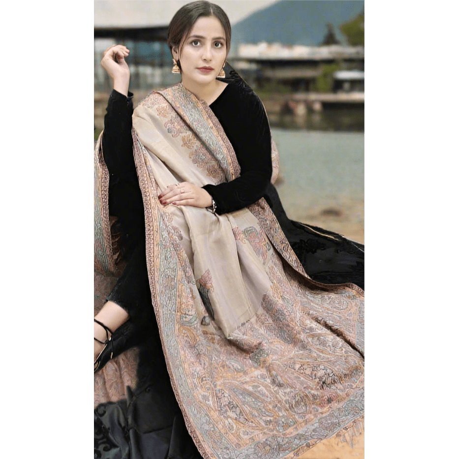 model displaying Kani Shawl Pashmina embroidered with pastel colors on all four borders. The base is beige. Available at Najmadesigns and Co.