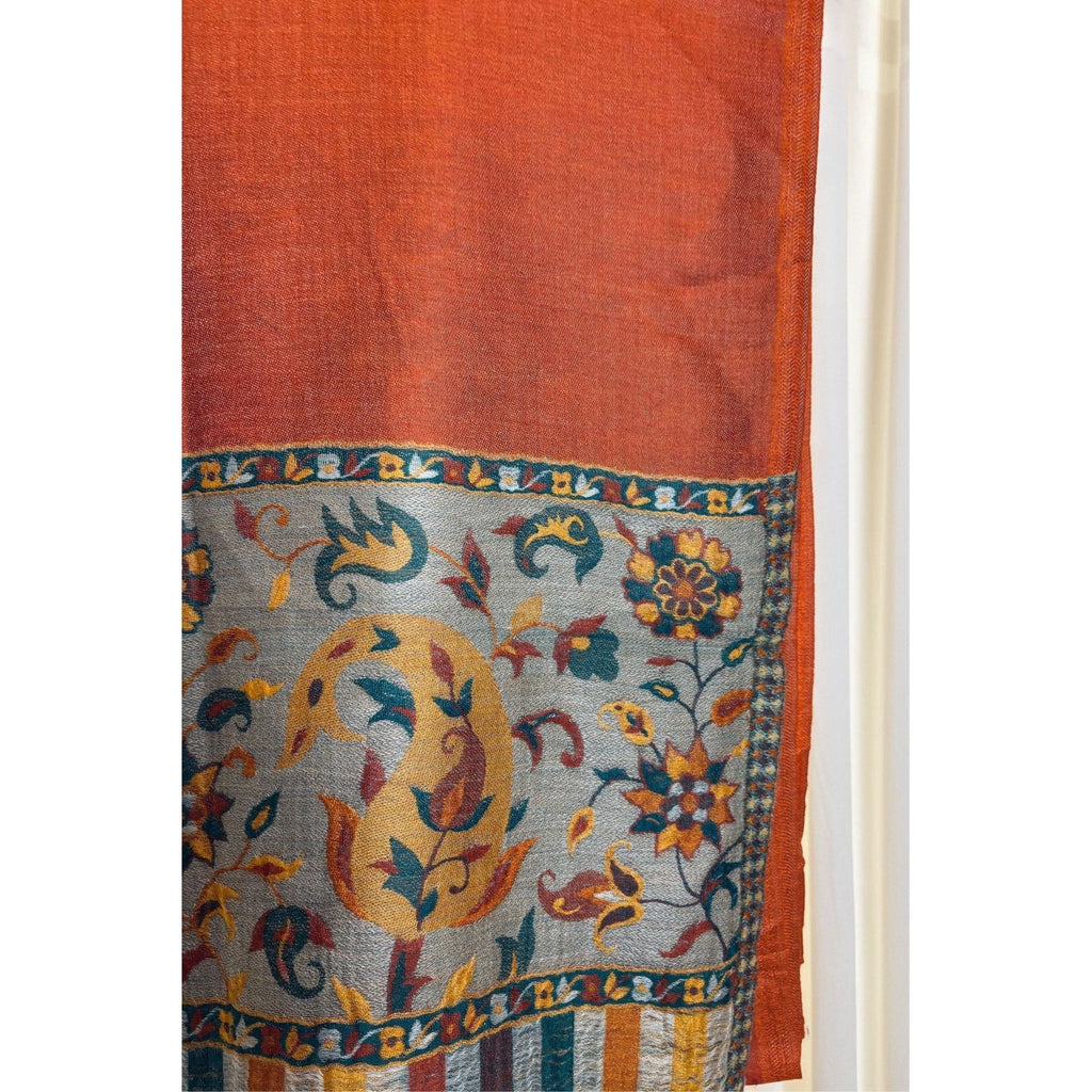 A lightweight, exquisite Shawl woven from Kani yarn in burnt orange hues. The Shawl features a pure silk Pashmina base and a delicate grey border. 
