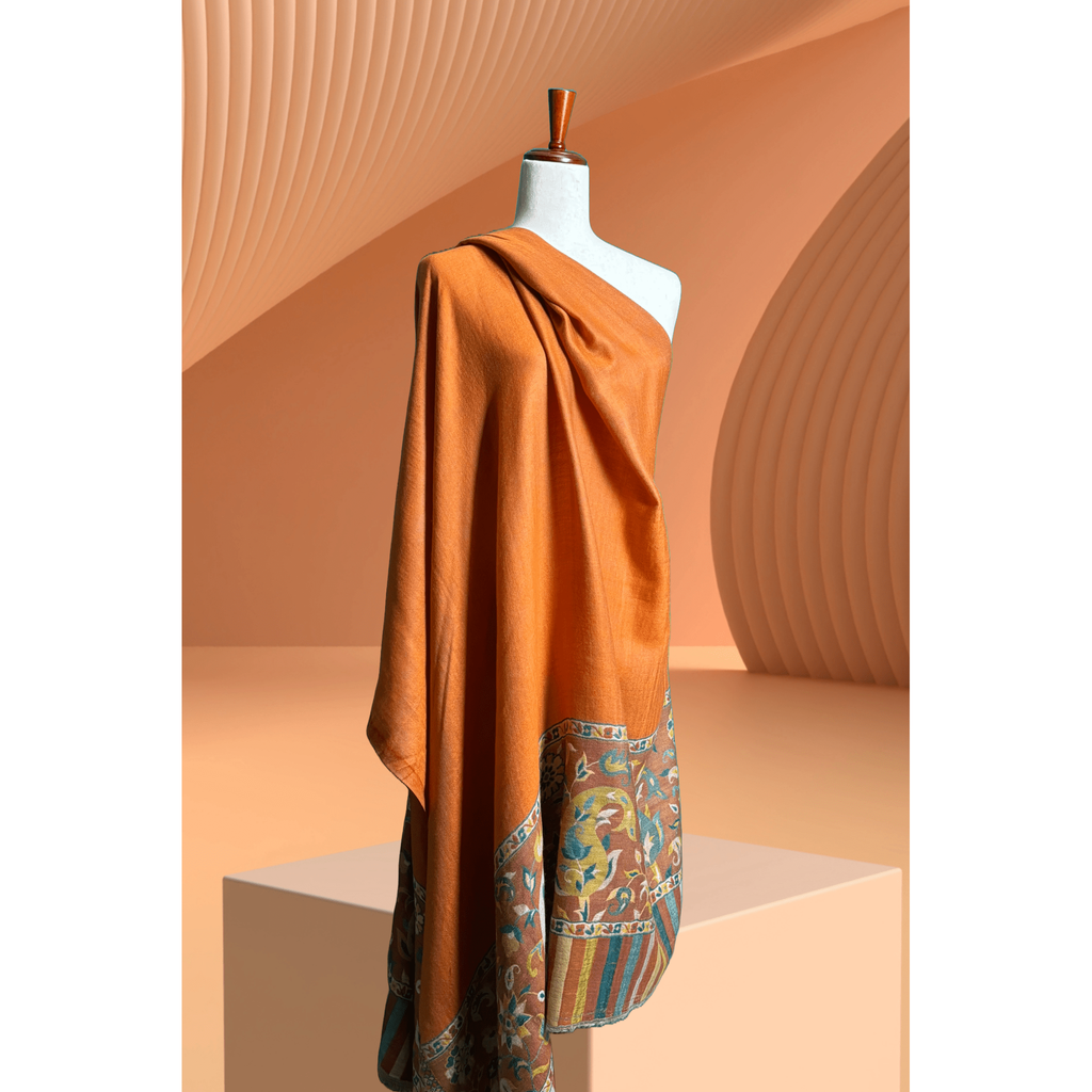 A lightweight, exquisite Shawl woven from Kani yarn in burnt orange hues. The Shawl features a pure silk Pashmina base and a delicate grey border. 