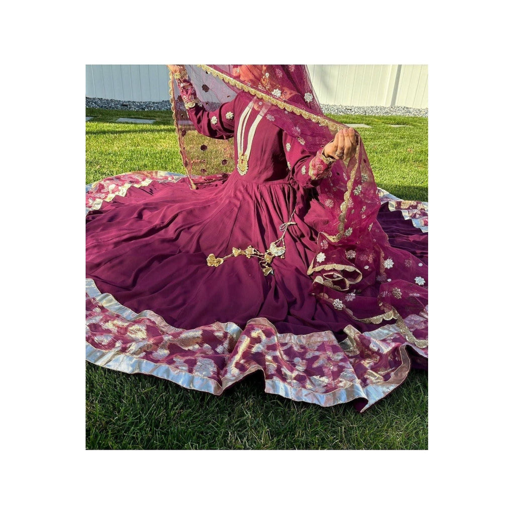 	The dress boasts a Peshwas-style design, adorned with 10 yards of vibrant flair, meticulously stitched in 32 kaliyahs or panels. It features three layers, with a crinoline slip attached, and a mulberry-colored Banarasi border. The designer behind this exquisite creation is Naijamadesigns and Co.
