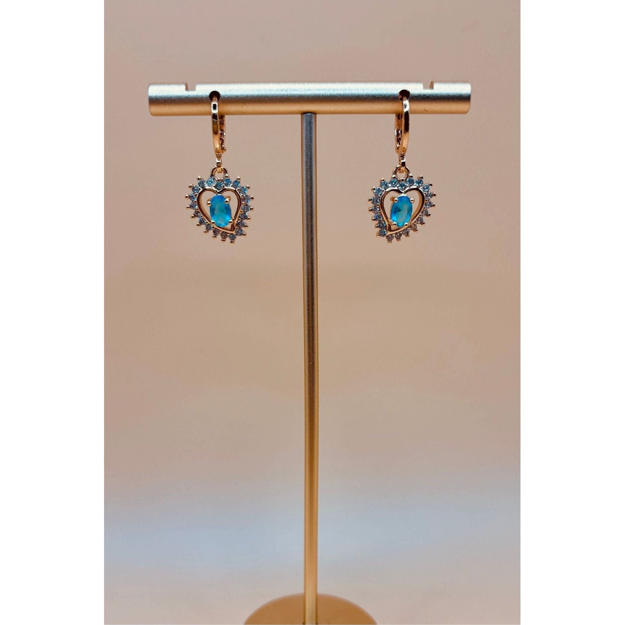 These Ocean Heart Earrings feature a beautiful rhinestone heart shape design, adorned with sparkling crystals. Made with high-quality materials and finished with a 1 carat gold plating, these elegant earrings are sure to elevate any outfit. Dangle them for a touch of sophistication and style.