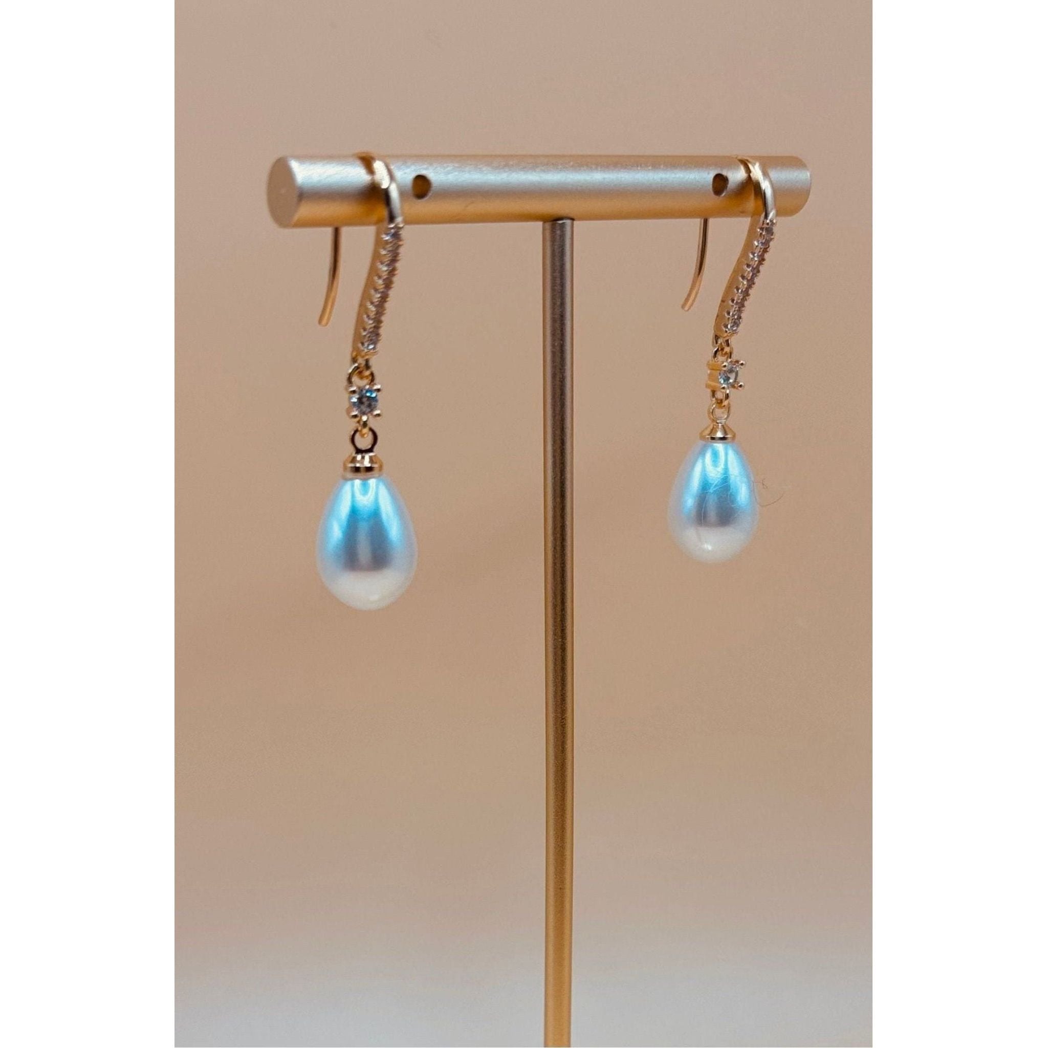 The Pearl Earring is a timeless piece that exudes elegance with its polished finish and combination of crystal and pearl. Elevate any outfit with its sophisticated and refined touch. A must-have for any jewelry collection. 1-carat gold plated 🤍