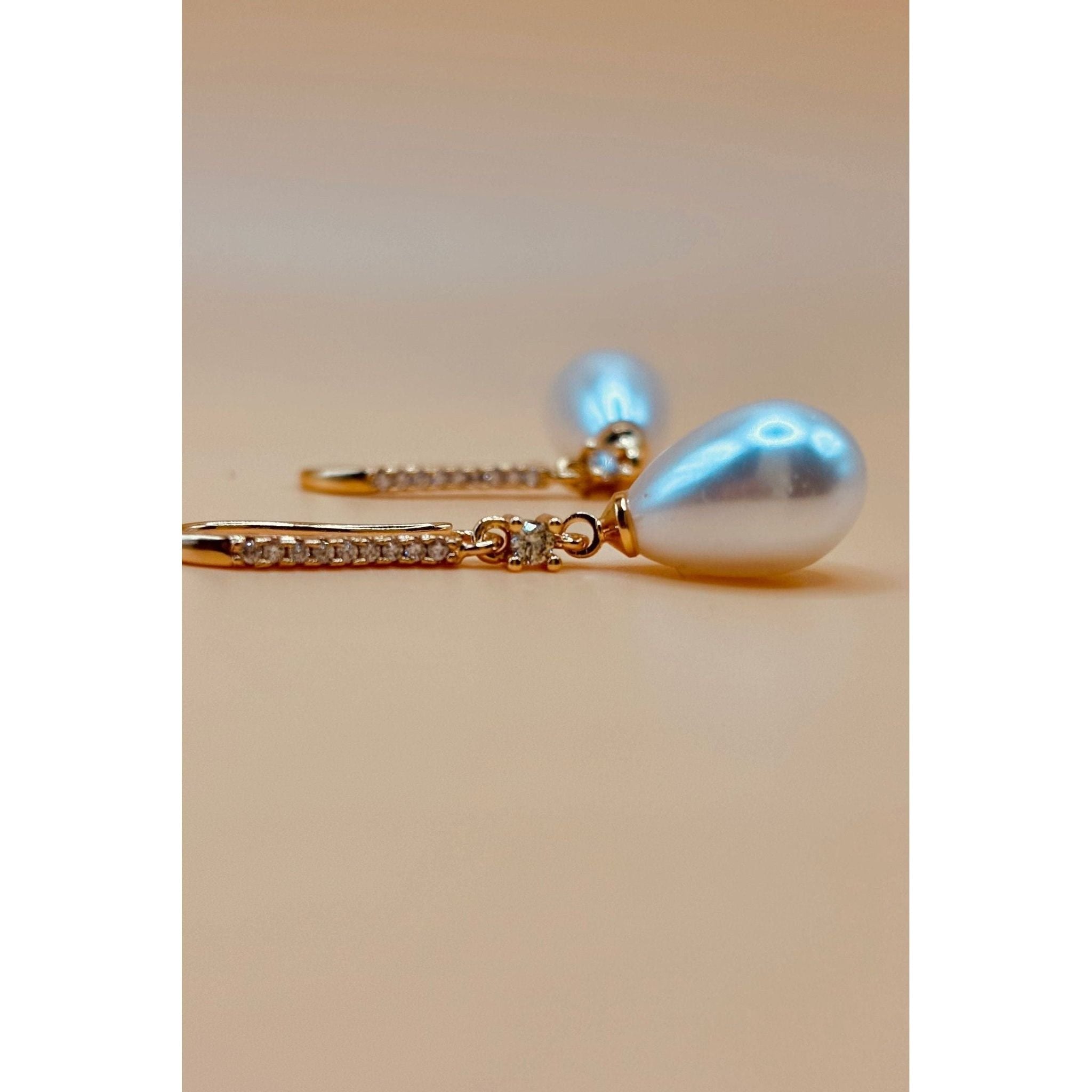 The Pearl Earring is a timeless piece that exudes elegance with its polished finish and combination of crystal and pearl. Elevate any outfit with its sophisticated and refined touch. A must-have for any jewelry collection. 1-carat gold plated 🤍