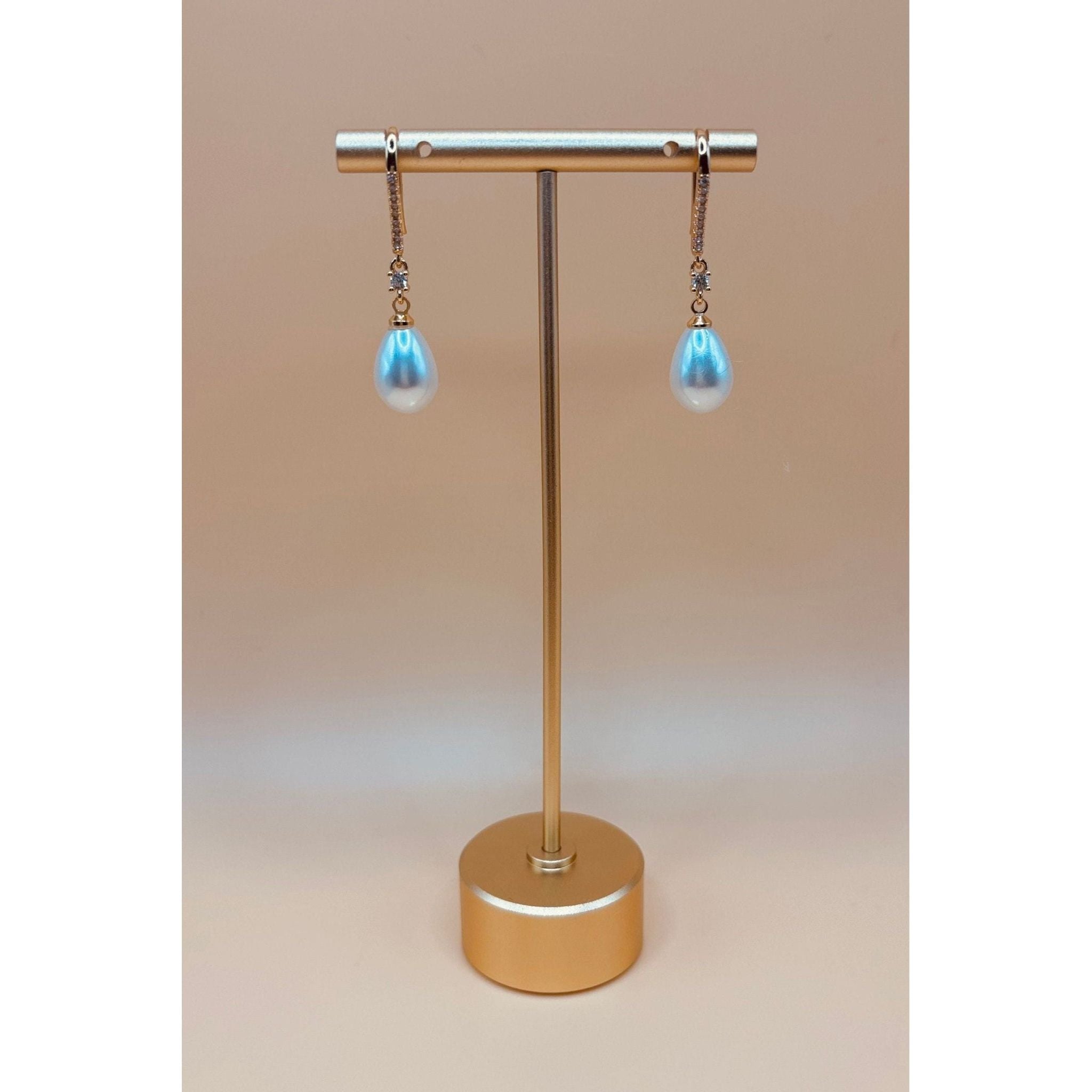 The Pearl Earring is a timeless piece that exudes elegance with its polished finish and combination of crystal and pearl. Elevate any outfit with its sophisticated and refined touch. A must-have for any jewelry collection. 1-carat gold plated 🤍