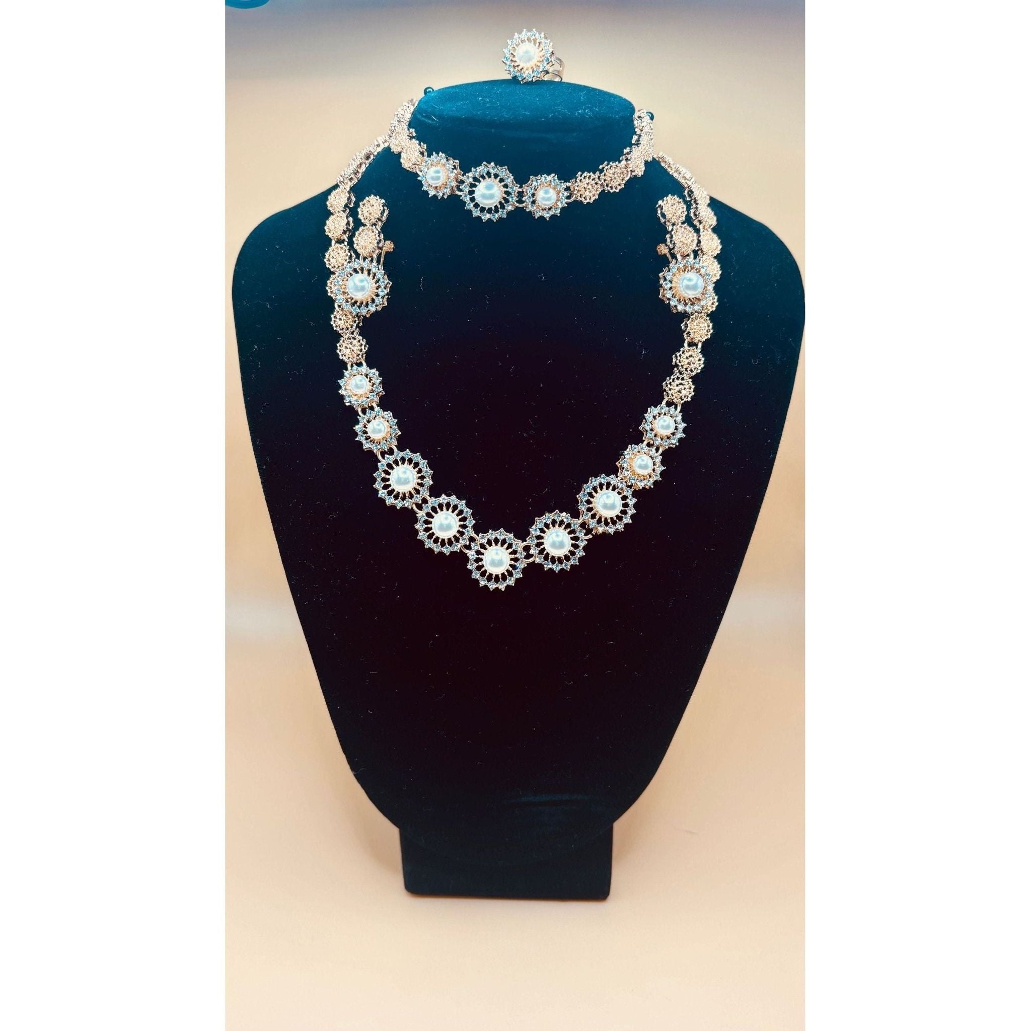 This beautiful pearl set features a one-carat gold setting. It includes an earring bracelet, a ring, and a necklace. 