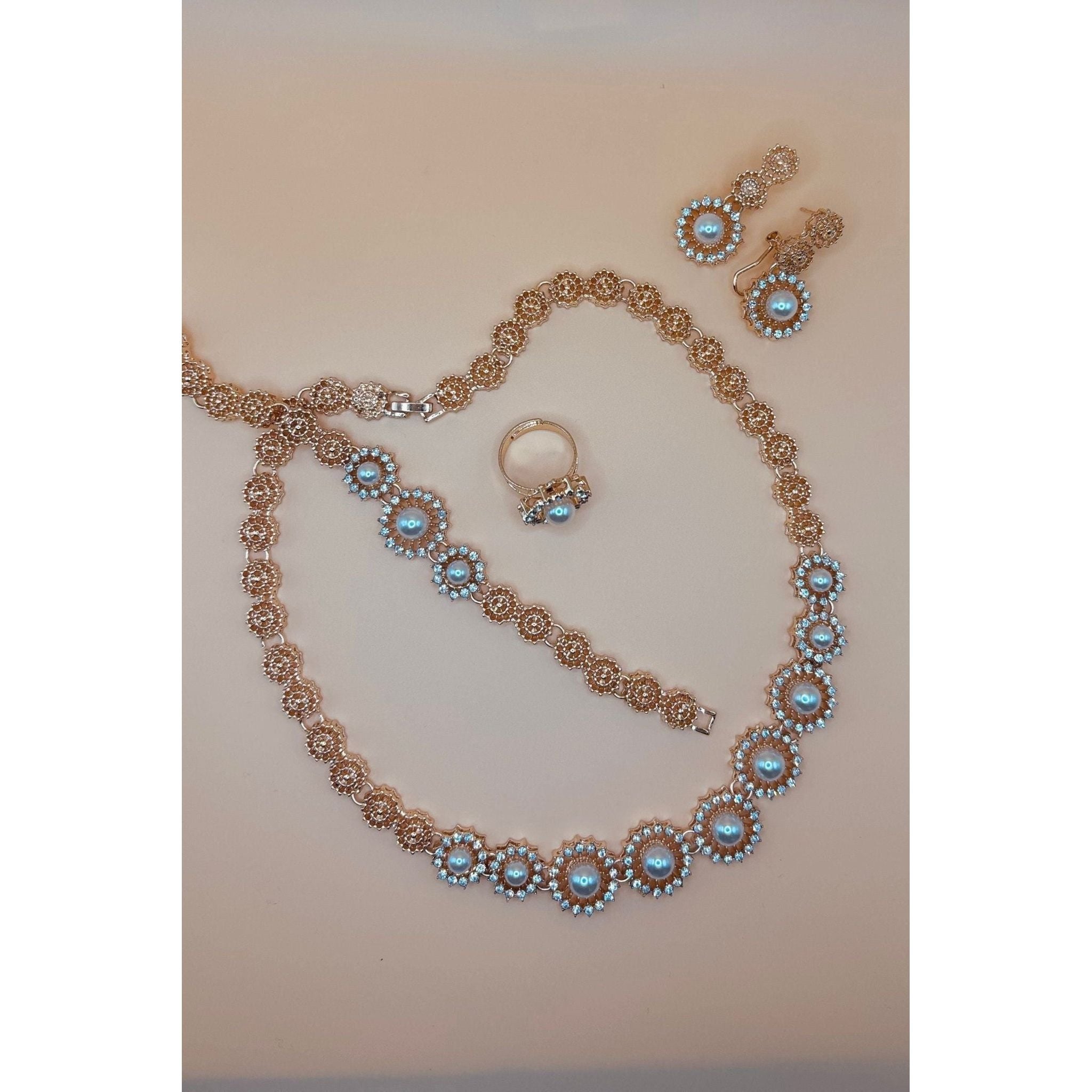 This beautiful pearl set features a one-carat gold setting. It includes an earring bracelet, a ring, and a necklace. 