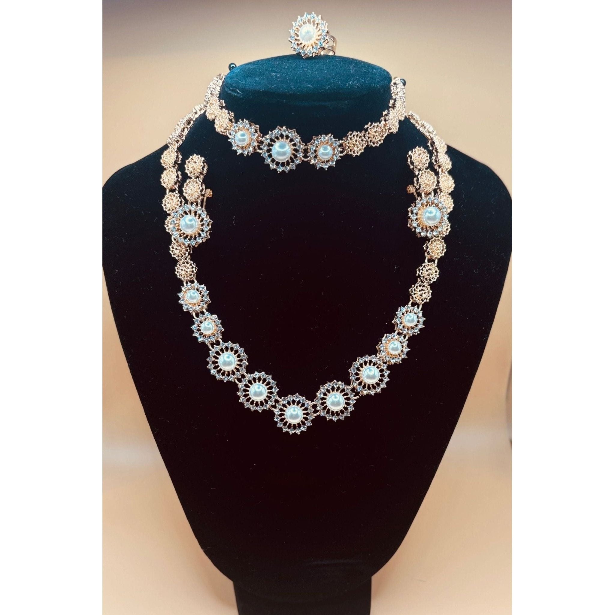 This beautiful pearl set features a one-carat gold setting. It includes an earring bracelet, a ring, and a necklace. 