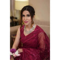 The stitched Sari comes with attached sleeves embroidered with sequenced work in the magenta color. Made in Pakistan, it’s available for purchase at NajmaDesigns and Co.