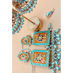 Beautiful handmade earring in light blue and rust color, featuring a pear hanging from it. 