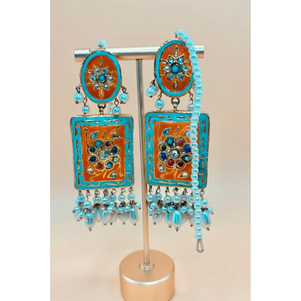 Beautiful handmade earring in light blue and rust color, featuring a pear hanging from it. 